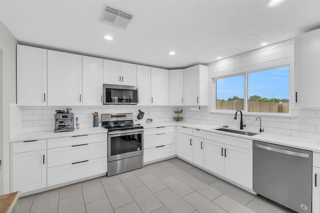 19702 Franz Rd, Houston, TX 77084 - kitchen with stainless steel appliances, light countertops, backsplash, recessed lighting, and white cabinetry