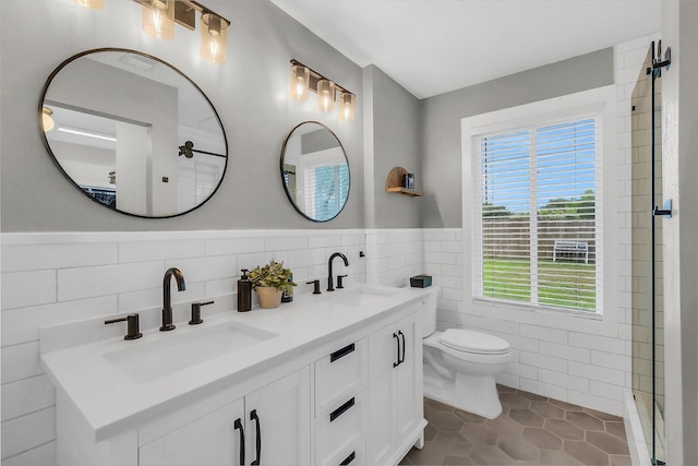 19702 Franz Rd, Houston, TX 77084 - full bathroom featuring tile walls, double vanity, tile patterned floors, wainscoting, and a shower