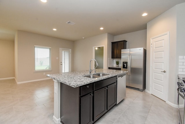 5602 Cedar Crescent Ct, Richmond, TX 77407 - kitchen with stainless steel appliances, an island with sink, light stone counters, light tile patterned floors, and recessed lighting