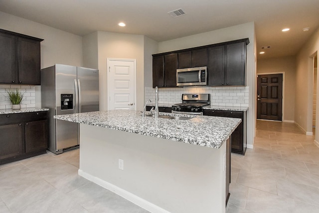 5602 Cedar Crescent Ct, Richmond, TX 77407 - kitchen with stainless steel appliances, light stone counters, decorative backsplash, recessed lighting, and a center island with sink