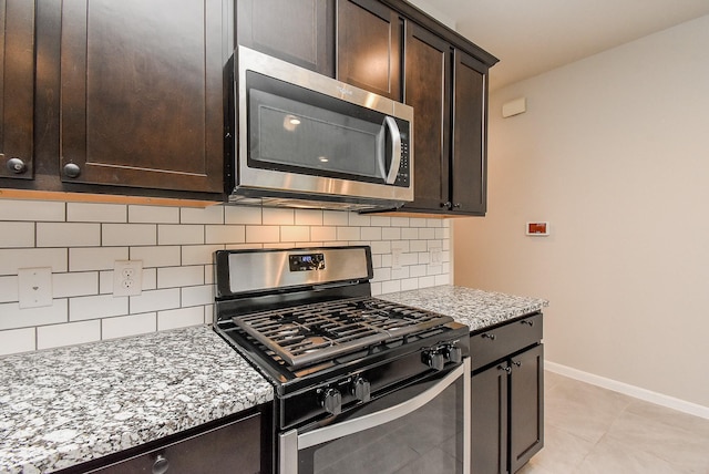 5602 Cedar Crescent Ct, Richmond, TX 77407 - kitchen featuring stainless steel appliances, dark brown cabinets, decorative backsplash, light stone countertops, and light tile patterned flooring