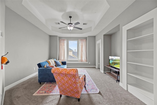 27410 Villa Mountain Ct, Fulshear, TX 77441 - carpeted living room featuring a ceiling fan, a tray ceiling, and built in shelves