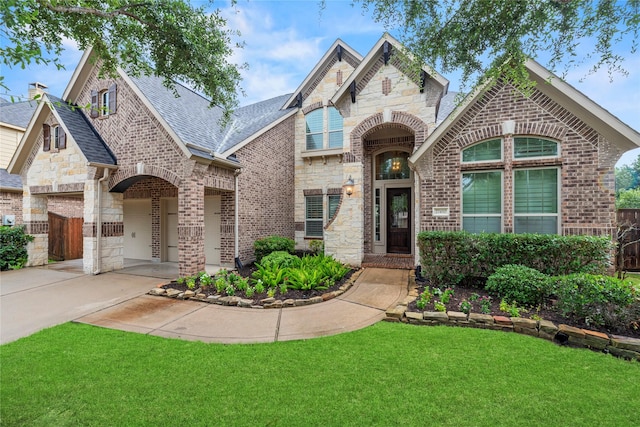 27410 Villa Mountain Ct, Fulshear, TX 77441 - french provincial home with driveway, a front yard, brick siding, stone siding, and a garage