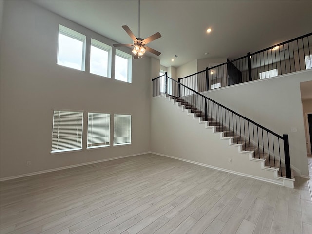 8116 Tourmaline Way, Texas City, TX 77591 - unfurnished living room with a ceiling fan, light wood-type flooring, stairs, a high ceiling, and recessed lighting