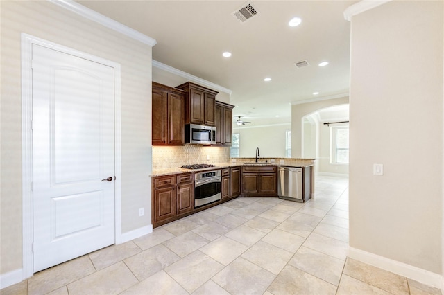 4927 Caponi Falls Ln, Katy, TX 77494 - kitchen with stainless steel appliances, ornamental molding, arched walkways, a peninsula, and tasteful backsplash