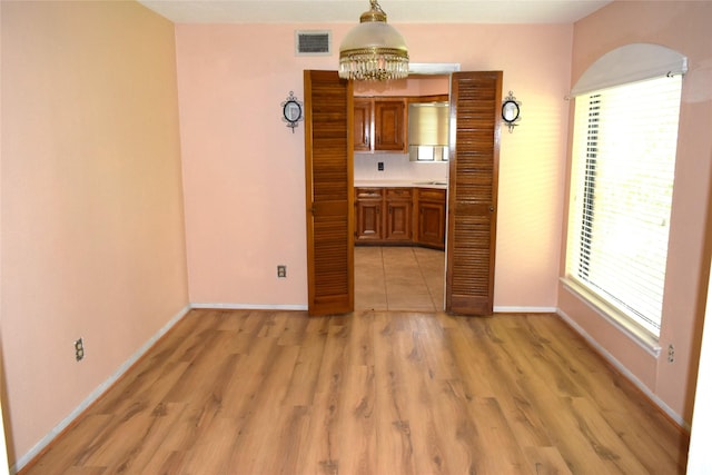 7331 Rancho Mission Dr, Houston, TX 77083 - empty room featuring a chandelier and light wood-style floors