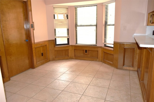 7331 Rancho Mission Dr, Houston, TX 77083 - unfurnished dining area with wainscoting, plenty of natural light, and light tile patterned floors