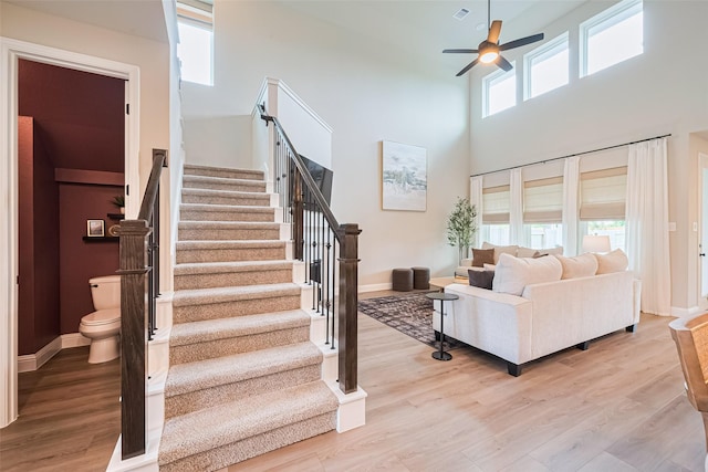 21031 Secretariat Meadow Ln, Tomball, TX 77377 - staircase featuring ceiling fan, wood finished floors, and a high ceiling