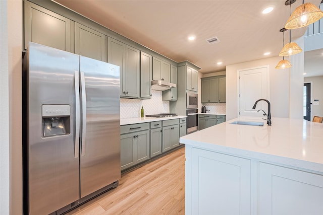 21031 Secretariat Meadow Ln, Tomball, TX 77377 - kitchen featuring stainless steel appliances, gray cabinetry, light wood-style flooring, backsplash, and recessed lighting