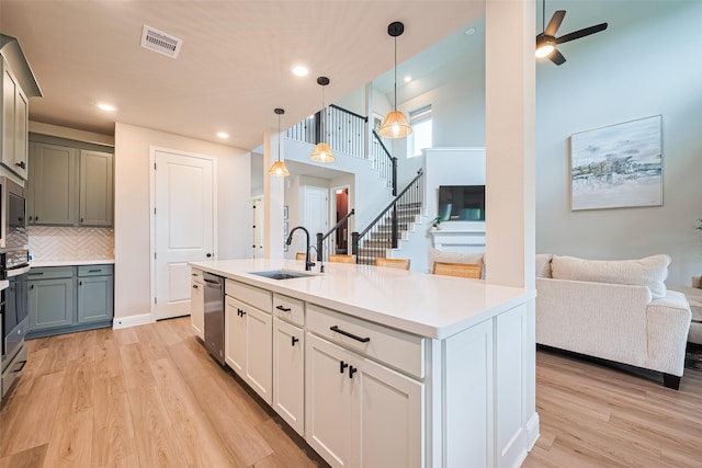 21031 Secretariat Meadow Ln, Tomball, TX 77377 - kitchen featuring appliances with stainless steel finishes, open floor plan, light wood finished floors, decorative backsplash, and light countertops