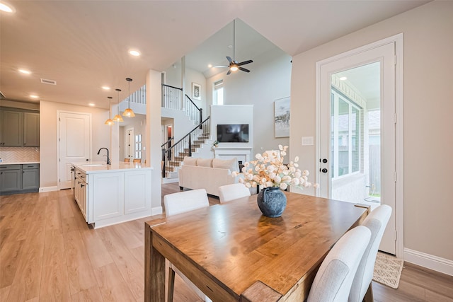 21031 Secretariat Meadow Ln, Tomball, TX 77377 - dining space featuring light wood-style floors, ceiling fan, healthy amount of natural light, stairs, and recessed lighting