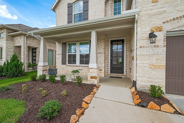 21031 Secretariat Meadow Ln, Tomball, TX 77377 - property entrance with covered porch, a garage, and stone siding