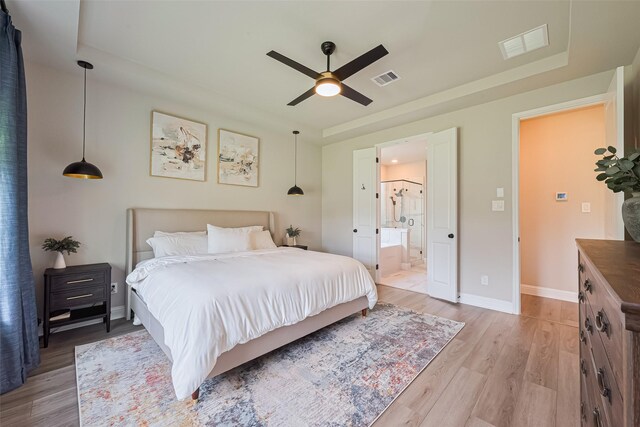 21031 Secretariat Meadow Ln, Tomball, TX 77377 - bedroom featuring light wood finished floors, a raised ceiling, ensuite bathroom, and a ceiling fan