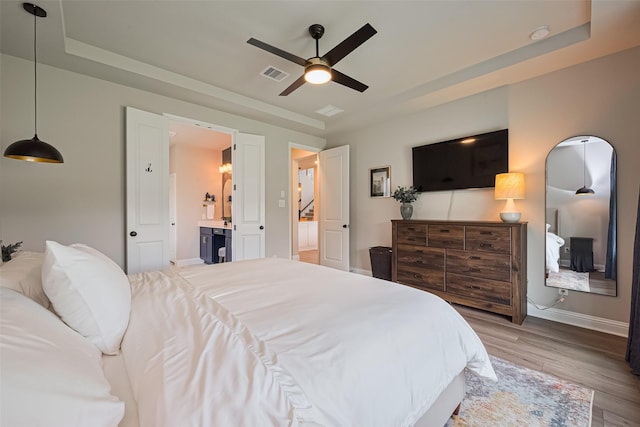 21031 Secretariat Meadow Ln, Tomball, TX 77377 - bedroom with a raised ceiling, wood finished floors, a ceiling fan, and ensuite bathroom