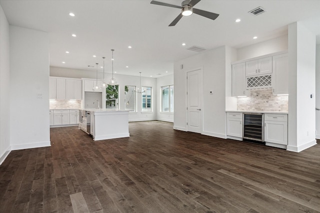 1609 Roy St, Houston, TX 77007 - unfurnished living room featuring wine cooler, bar, dark wood-style floors, a ceiling fan, and recessed lighting