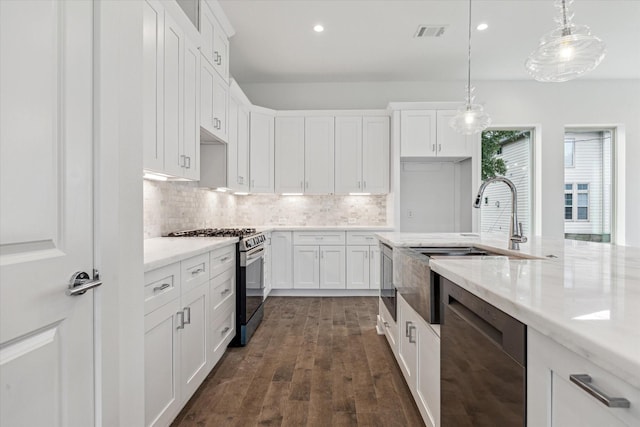 1609 Roy St, Houston, TX 77007 - kitchen featuring appliances with stainless steel finishes, white cabinetry, decorative backsplash, dark wood-type flooring, and hanging light fixtures