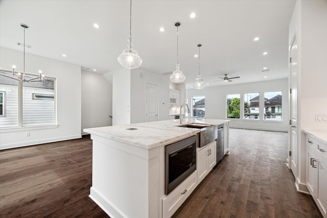 1609 Roy St, Houston, TX 77007 - kitchen with stainless steel appliances, open floor plan, dark wood-type flooring, white cabinetry, and a center island with sink