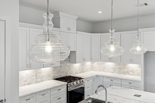 1609 Roy St, Houston, TX 77007 - kitchen with stainless steel gas range, white cabinetry, tasteful backsplash, pendant lighting, and light stone counters