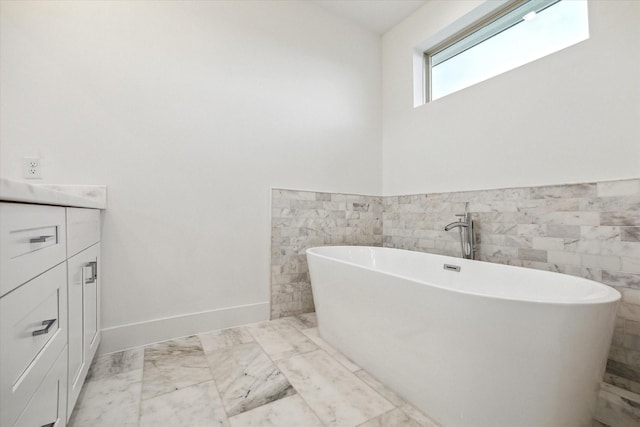 1609 Roy St, Houston, TX 77007 - bathroom with a freestanding tub, vanity, tile walls, a wainscoted wall, and marble finish floors