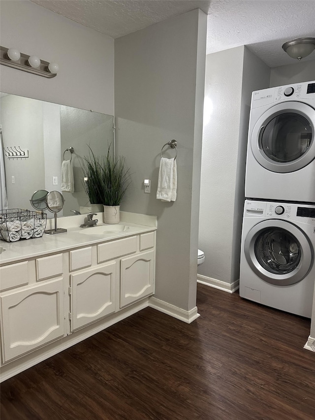 2379 Briarwest Blvd Unit 12, Houston, TX 77077 - bathroom with stacked washing machine and dryer, a textured ceiling, wood finished floors, and vanity