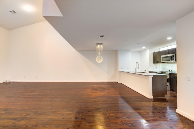 2902 Commerce St, Houston, TX 77003 - kitchen with stainless steel appliances, dark wood-style floors, a peninsula, recessed lighting, and open floor plan