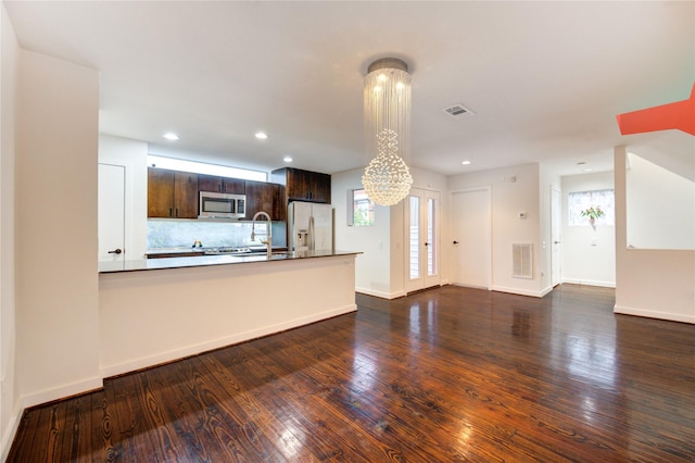 2902 Commerce St, Houston, TX 77003 - kitchen with stainless steel microwave, fridge with ice dispenser, a chandelier, dark wood-type flooring, and dark brown cabinetry
