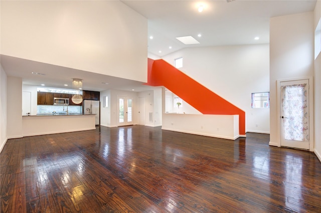 2902 Commerce St, Houston, TX 77003 - unfurnished living room with high vaulted ceiling, dark wood-style flooring, recessed lighting, and a skylight