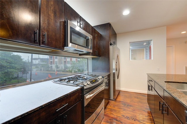 2902 Commerce St, Houston, TX 77003 - kitchen with appliances with stainless steel finishes, dark wood finished floors, stone countertops, dark brown cabinets, and recessed lighting