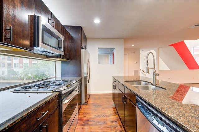 2902 Commerce St, Houston, TX 77003 - kitchen featuring appliances with stainless steel finishes, dark wood-style floors, recessed lighting, dark stone counters, and dark brown cabinetry