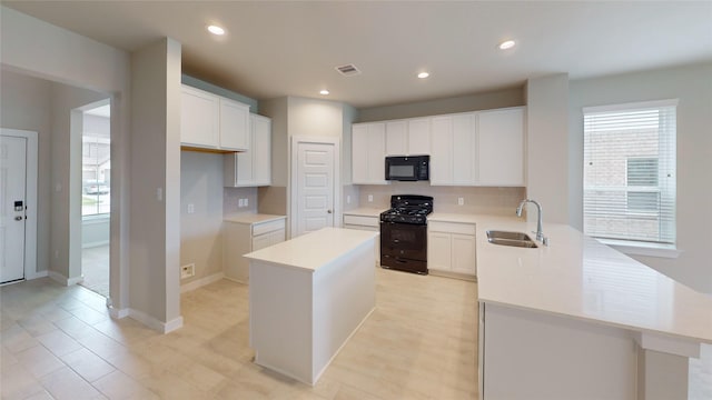 333 Spruce Oak Ln, Waller, TX 77484 - kitchen featuring black appliances, a peninsula, tasteful backsplash, light countertops, and a center island