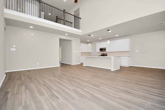 22006 Big Sky Dr, Tomball, TX 77375 - unfurnished living room with a high ceiling, light wood-style flooring, recessed lighting, and a ceiling fan