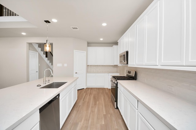 22006 Big Sky Dr, Tomball, TX 77375 - kitchen with stainless steel appliances, light wood-type flooring, backsplash, light countertops, and pendant lighting