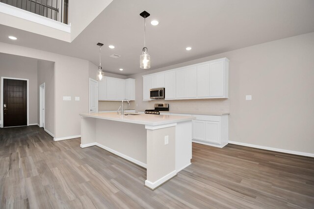 22006 Big Sky Dr, Tomball, TX 77375 - kitchen with appliances with stainless steel finishes, light wood-style flooring, light countertops, recessed lighting, and a kitchen island with sink