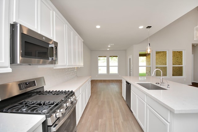 22006 Big Sky Dr, Tomball, TX 77375 - kitchen featuring stainless steel appliances, light wood-type flooring, backsplash, white cabinets, and light countertops