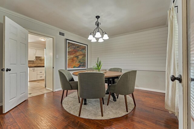 6103 Allentown Dr, Spring, TX 77389 - dining space featuring a chandelier, crown molding, dark wood finished floors, and wood walls