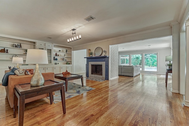 6103 Allentown Dr, Spring, TX 77389 - living area featuring a brick fireplace, light wood finished floors, ornamental molding, and a chandelier
