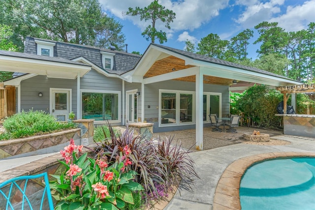 6103 Allentown Dr, Spring, TX 77389 - rear view of house with a patio, a shingled roof, an outdoor pool, and a fire pit