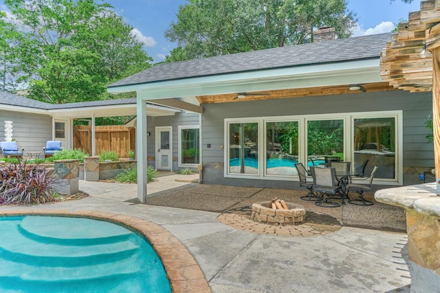 6103 Allentown Dr, Spring, TX 77389 - back of property with an outdoor fire pit, a patio area, a chimney, and an outdoor pool
