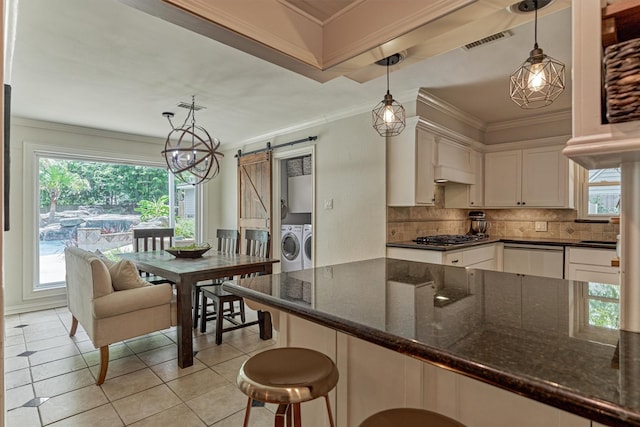 6103 Allentown Dr, Spring, TX 77389 - kitchen featuring washing machine and clothes dryer, a barn door, dishwashing machine, decorative backsplash, and crown molding