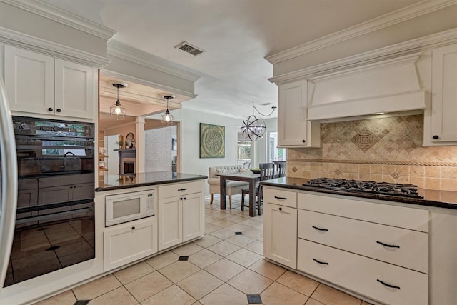 6103 Allentown Dr, Spring, TX 77389 - kitchen featuring white microwave, gas cooktop, backsplash, light tile patterned flooring, and crown molding
