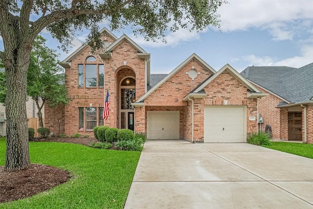 8812 Snowy Owl Loop, Missouri City, TX 77459 - traditional-style home with a front yard, driveway, brick siding, and a garage