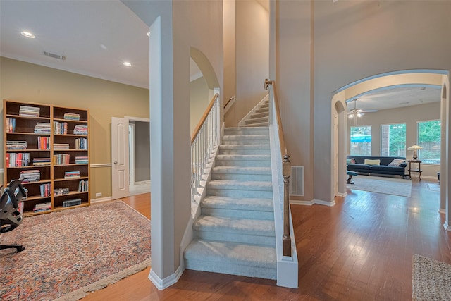 8812 Snowy Owl Loop, Missouri City, TX 77459 - stairs with arched walkways, wood finished floors, a ceiling fan, recessed lighting, and a high ceiling