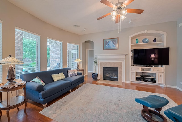 8812 Snowy Owl Loop, Missouri City, TX 77459 - living area featuring wood finished floors, ceiling fan, a high end fireplace, built in features, and arched walkways