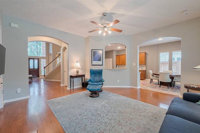 8812 Snowy Owl Loop, Missouri City, TX 77459 - living room with plenty of natural light, arched walkways, ceiling fan, and light wood finished floors
