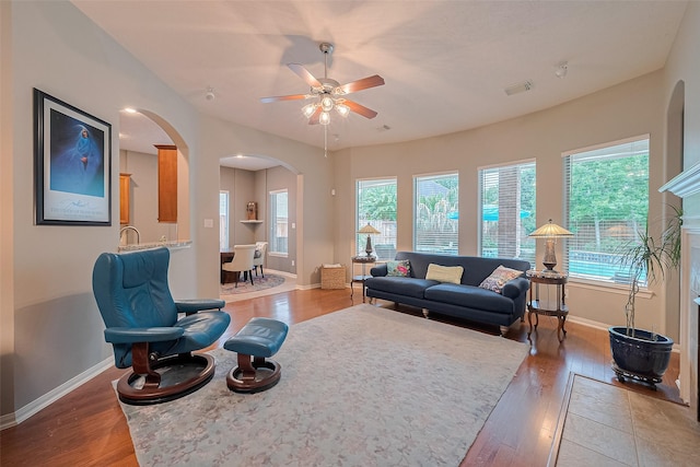 8812 Snowy Owl Loop, Missouri City, TX 77459 - living area featuring arched walkways, light wood finished floors, and a ceiling fan
