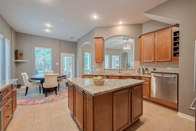8812 Snowy Owl Loop, Missouri City, TX 77459 - kitchen featuring stainless steel dishwasher, backsplash, healthy amount of natural light, arched walkways, and recessed lighting