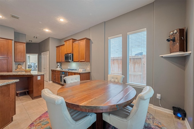 8812 Snowy Owl Loop, Missouri City, TX 77459 - dining space with light tile patterned floors, recessed lighting, and separate washer and dryer