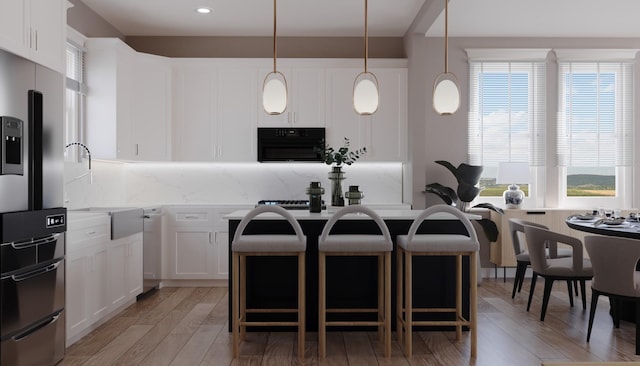 2428 Ella Blvd, Houston, TX 77008 - kitchen featuring tasteful backsplash, healthy amount of natural light, a breakfast bar, a kitchen island, and recessed lighting