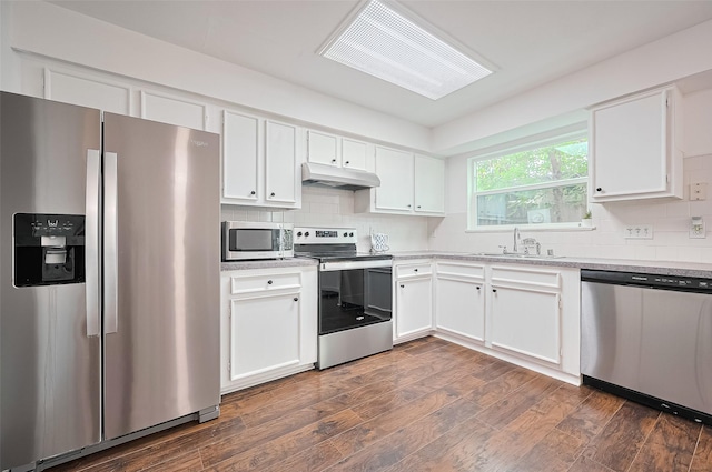 10174 Beekman Place Dr, Houston, TX 77043 - kitchen featuring appliances with stainless steel finishes, under cabinet range hood, white cabinets, and backsplash
