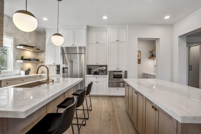 4991 Dumfries Dr, Houston, TX 77096 - kitchen with high end refrigerator, a spacious island, tasteful backsplash, light wood-type flooring, and recessed lighting